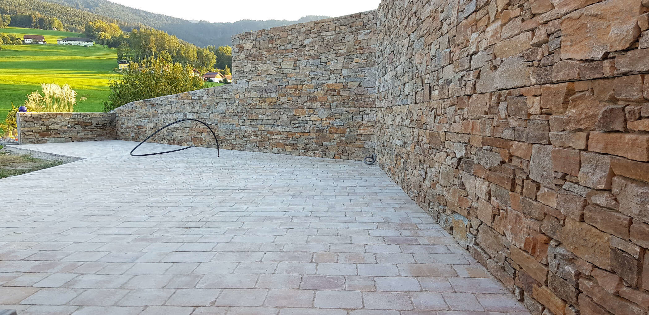 Steinmauer und Pflasterung von Meister Granit